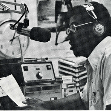 Black student speaks into radio microphone.