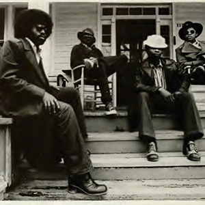 This photo depicts four W&L students relaxing on the front porch of their house in 1974 wearing SABU jackets.