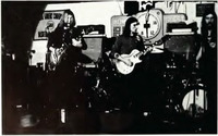 Two guitarists and a drummer from the Allman Brothers Band playing onstage